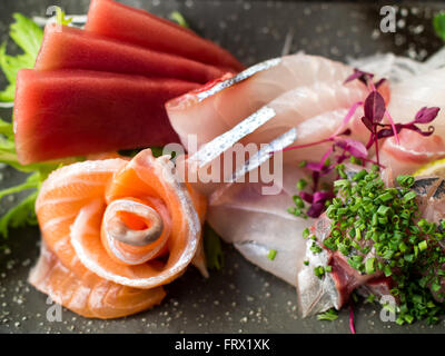 Poisson cru japonais sur la plaque noire. Également connu sous le nom de sashimi. Banque D'Images