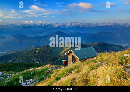 L'arrivée d'un randonneur au sommet du chalet de montagne Benediktenwand, Karwendel en arrière-plan, les Préalpes bavaroises, Upper Bavaria, Bavaria, Germany Banque D'Images