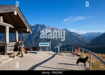 Les randonneurs se reposant à une cabane sur le haut de Hoher Kranzberg, vue sur le massif des Karwendel, près de Mittenwald, Bavière, Allemagne Banque D'Images