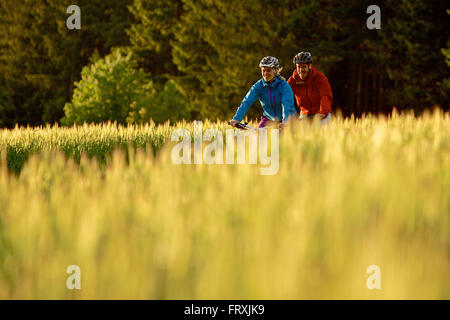 Deux cyclistes équitation vélos électriques entre les champs, Tanna, Thuringe, Allemagne Banque D'Images