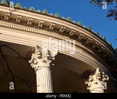 Cresting décoratif, denticules, colonnes corinthiennes et plus ornent la ligne du toit et de la façade d'un porche sur un beau vieux Vi Banque D'Images