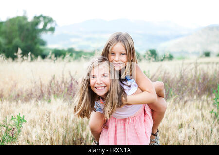 Espagne, Girona, portrait de deux sœurs heureux jouant sur un pré Banque D'Images