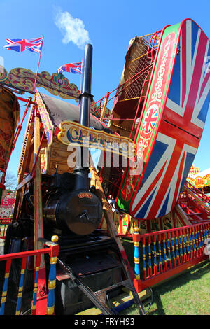 Southend on Sea, Royaume-Uni. 25 mars 2016. Balançoire à vapeur richement décorée gérée par carters Steam Fair, ornée de motifs Union Jack, de détails en laiton et de drapeaux britanniques. Le trajet fait partie d'une foire vintage itinérante célébrant les divertissements traditionnels britanniques. La vapeur jaillit du moteur, ajoutant authenticité et atmosphère à cette scène nostalgique. Carter's Steam Fair est à Southend pour les vacances de Pâques. La célèbre foire amusante vintage avec une gamme de manèges magnifiquement restaurés. Penelope Barritt/Alamy Live News Banque D'Images