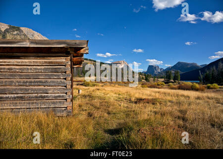 WYOMING - Vieux Osborn cabine située dans la perspective de la baisse de la rivière Green Lake et Squaretop Mountain dans la forêt nationale de Teton. Banque D'Images