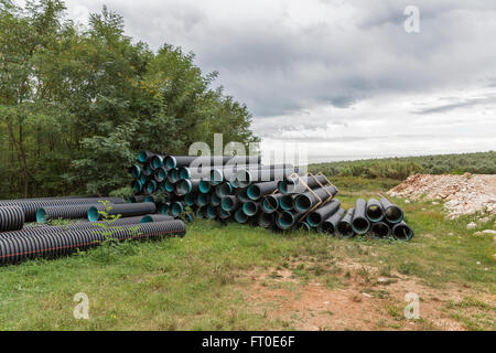 Pile de tuyaux en pvc construction sur un chantier dans la forêt Banque D'Images