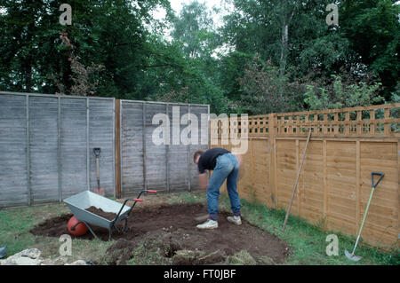 Gardener creuser hors zone d'une pelouse pour faire une nouvelle rocaille pour un usage éditorial uniquement Banque D'Images