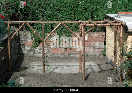 Une pergola en bois rustique récemment aménagée dans un jardin en rénovation Banque D'Images