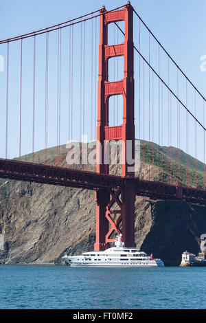 Yacht blanc passe sous le golden gate bridge sur une journée ensoleillée Banque D'Images