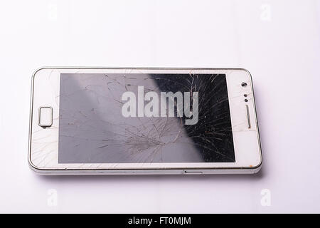 Smartphone tomber à terre et les dommages de l'écran sur fond blanc cassé Banque D'Images