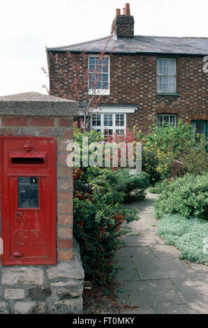 Boite aux lettres rouge en mur à côté jardin à l'avant du cottage semi-détaché traditionnels Banque D'Images