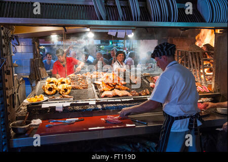 La préparation des cuisiniers et de la viande de boeuf, type Parilla restaurant, Mercado del Puerto, Montevideo, Montevideo, Uruguay Banque D'Images