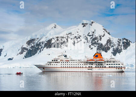 Expedition cruise ship MS Hanseatic Hapag-Lloyd Cruises et montagnes couvertes de glace, Lemaire Channel, près de la Terre de Graham, en Antarctique Banque D'Images