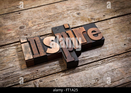 Inspirer, mot écrit avec la typographie vintage blocks sur fond de bois rustique, coudée view Banque D'Images