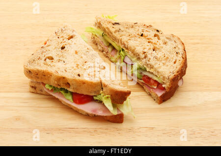 Deux moitiés de pain grenier salade de jambon sandwichs sur une planche en bois Banque D'Images