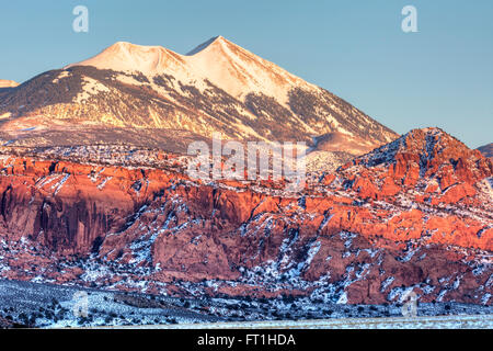 Mt. Tukuhnikivatz & Mt. Peale dans la montagne au coucher du soleil d'hiver LaSal, derrière les roches rouges de Moab, Utah. Banque D'Images