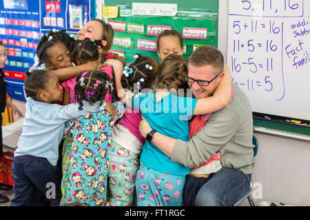 Pontiac, Michigan - les enfants de maternelle hug bénévoles de Fiat Chrysler qui ont lu des livres pour eux. Banque D'Images