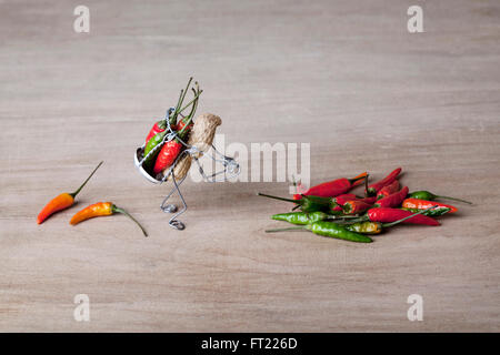 Miniature avec worker carrying arachides piments rouges et verts Banque D'Images