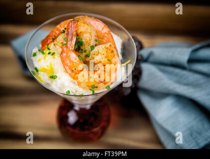 Petite assiette de crevettes et grits dans un verre à martini. Banque D'Images