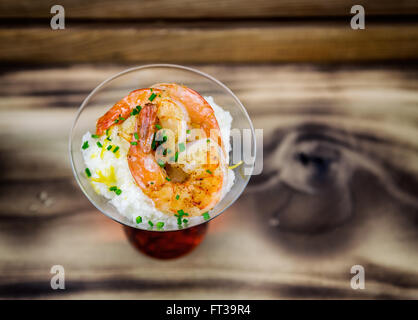 Petite assiette de crevettes et grits dans un verre à martini. Banque D'Images