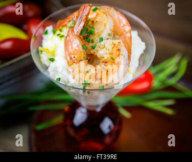 Petite assiette de crevettes et grits dans un verre à martini. Banque D'Images