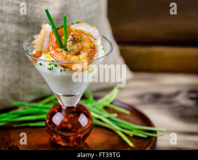 Petite assiette de crevettes et grits dans un verre à martini. Banque D'Images