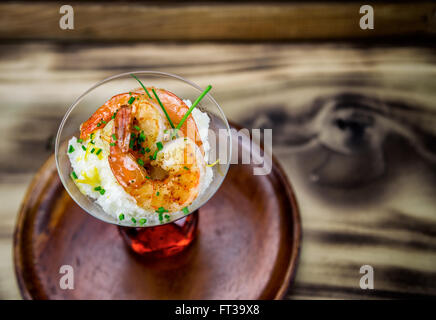 Petite assiette de crevettes et grits dans un verre à martini. Banque D'Images