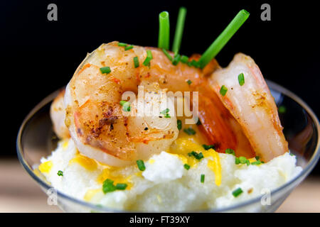 Petite assiette de crevettes et grits dans un verre à martini. Banque D'Images