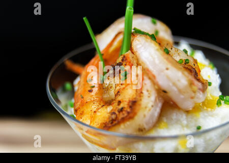 Petite assiette de crevettes et grits dans un verre à martini. Banque D'Images