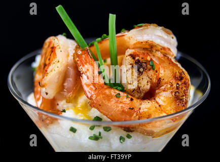 Petite assiette de crevettes et grits dans un verre à martini. Banque D'Images