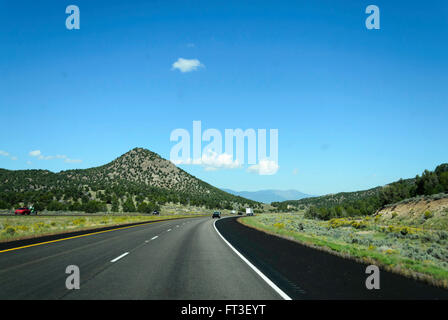 Autoroute menant à travers le col de montagne, arbres verts wide open space. ciel bleu. Banque D'Images