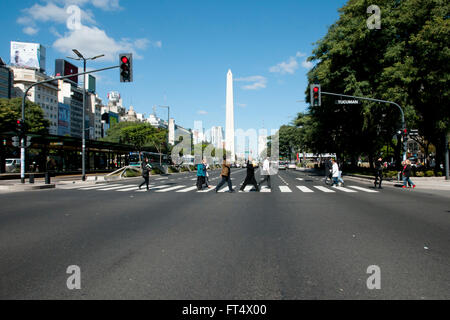 L'Obélisque vu loin sur l'Avenue 9 de Julio, tandis que les piétons traversent Banque D'Images