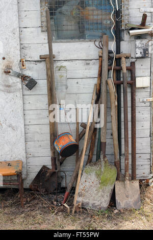 Les outils agricoles - pelles, une fourche, un râteau et une pioche à proximité d'un abri en milieu rural. Sur la terre, il est possible de remarquer une dead Banque D'Images