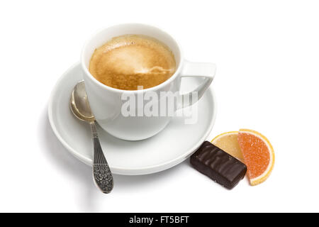 Une tasse de café, petite cuillère et les bonbons sur une plaque, gros plan sur un fond blanc Banque D'Images