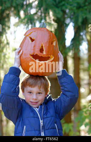 Un équilibrage garçon Halloween citrouille sur sa tête à l'automne, Bavière, Allemagne Banque D'Images