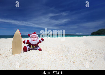 Santa Claus surfeur sur le sable à la plage de l'océan tropical, Noël et Nouvel An vacances d'hiver concept Banque D'Images