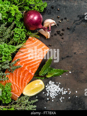 Filet de poisson Saumon aux fines herbes et épices sur fond foncé table de cuisine. Fruits de mer Banque D'Images