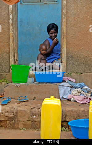 Kampala, Ouganda 12 avril 2017 femme est lave son enfant sur l'étape d'avant rendez sa maison Banque D'Images