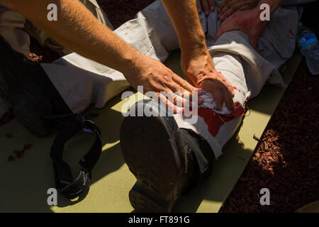 Bureau de la CBP et les pilotes de suivre une formation avec des scénarios d'accident simulation de blessures graves à un centre de formation nationale de l'air location de Oklahoma City, Oklahoma. À l'aide d'acteurs cet élève simule une pression sur une plaie de la jambe. Photos par James Tourtellotte Banque D'Images