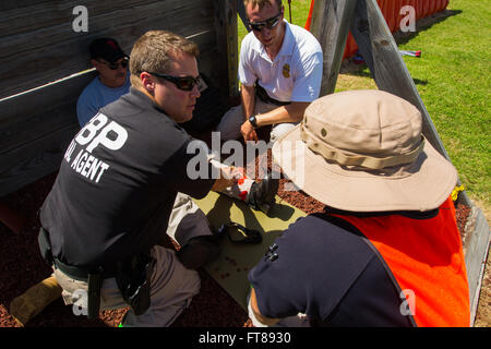 Bureau de la CBP et les pilotes de suivre une formation avec des scénarios d'accident simulation de blessures graves à un centre de formation nationale de l'air location de Oklahoma City, Oklahoma. À l'aide d'acteurs cet élève simule une pression sur une plaie de la jambe. Photos par James Tourtellotte Banque D'Images