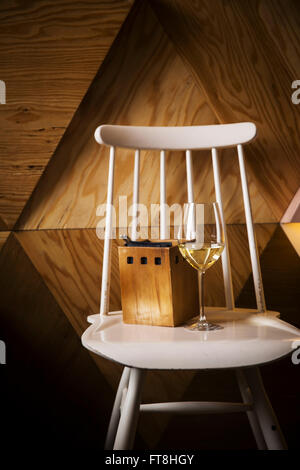 Verre de vin blanc debout sur une chaise vintage Banque D'Images