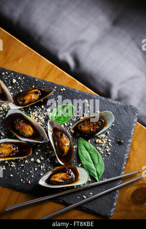 Plat asiatique - moules en sauce douce collante, avec l'arachide et aux épinards Banque D'Images