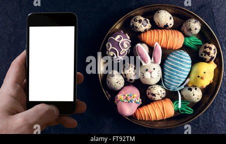 Servi avec des oeufs et de la plaque de Pâques cake pops sur fond sombre avec copie espace sur le téléphone Banque D'Images