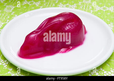 Un lapin de Pâques de gelée de framboise glitter sur une plaque blanche Banque D'Images