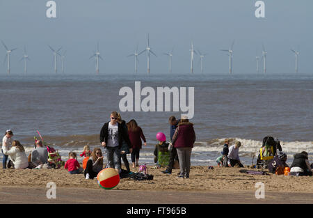 New Brighton, Wallasey. 25 mars 2016. Météo britannique. Les vacanciers appréciant le soleil du printemps sur la plage en face du phare de Fort perchaude. La Grande-Bretagne est de plus en plus friands de soi-disant staycations, avec des voyageurs de plus en plus disposé à prendre un court voyage sur ces rives au lieu de s'aventurer à l'étranger. Les événements en Europe peut maintenant affecter ces British personnes qui ont leurs vacances en juillet et août, les mois les plus populaires pour les vacances. Banque D'Images