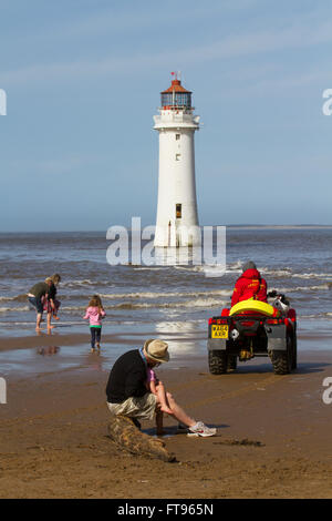 La patrouille de sauveteurs RNLI New Brighton Beach en utilisant un Honda TRX 500 FM (Quad), Wallasey, UK Les vacanciers appréciant le soleil du printemps sur la plage en face du phare de Fort perchaude. La Grande-Bretagne est de plus en plus friands de soi-disant staycations, avec des voyageurs de plus en plus disposé à prendre un court voyage sur ces rives au lieu de s'aventurer à l'étranger. Les événements en Europe peut maintenant affecter ces British personnes qui ont leurs vacances en juillet et août, les mois les plus populaires pour les vacances. Banque D'Images