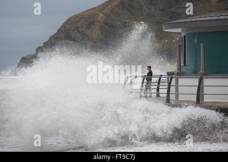 Aberystwyth, Pays de Galles, Royaume-Uni. 26 mars 2016. Un week-end férié. Comme des vagues s'écraser sur le nouveau kiosque à Aberystwyth, regardez sur les vacanciers, inconscients des dangers potentiels. Credit : Alan Hale/Alamy Live News Banque D'Images