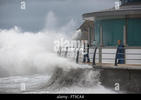 Aberystwyth, Pays de Galles, Royaume-Uni. 26 mars 2016. Un week-end férié. Comme des vagues s'écraser sur le nouveau kiosque à Aberystwyth, regardez sur les vacanciers, inconscients des dangers potentiels. Credit : Alan Hale/Alamy Live News Banque D'Images