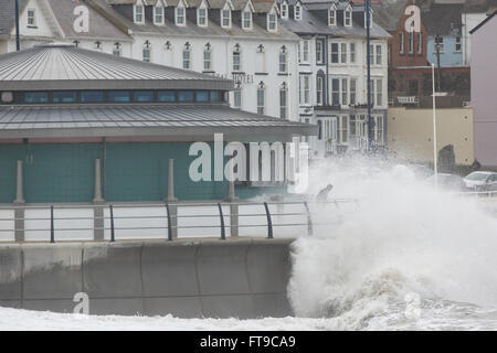 Aberystwyth, Pays de Galles, Royaume-Uni. 26 mars 2016. Un week-end férié. Comme des vagues s'écraser sur le nouveau kiosque à Aberystwyth, regardez sur les vacanciers, inconscients des dangers potentiels. Credit : Alan Hale/Alamy Live News Banque D'Images