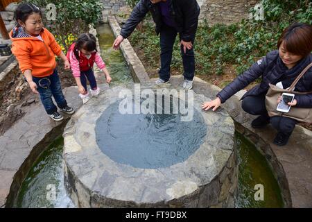 Anshun, dans la province du Guizhou en Chine. Mar 26, 2016. Les touristes jouer près d'une source dans la ville ancienne, Yuehua Middle Road 2007 Anshun City, au sud-ouest de la province du Guizhou, en Chine, le 26 mars 2016. Ancienne ville yuehua Middle Road 2007 est caractérisée de maisons en pierre, et elle a été signalée dans le troisième lot de la ville historique et culturelle de la renommée en 2007. Credit : Liu Xu/Xinhua/Alamy Live News Banque D'Images