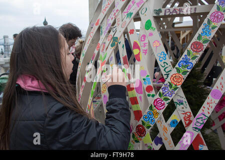 Budapest, Hongrie. Mar 26, 2016. Les gens décorent un oeuf en bois géant avec des motifs peints à la main dans le cadre de la célébration de Pâques à Budapest, Hongrie, le 26 mars 2016. © Attila Volgyi/Xinhua/Alamy Live News Banque D'Images